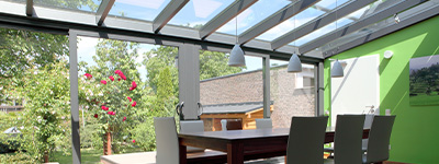 Wintergarten mit spitzem Dach und trapezförmigen Glasflächen © Schüco